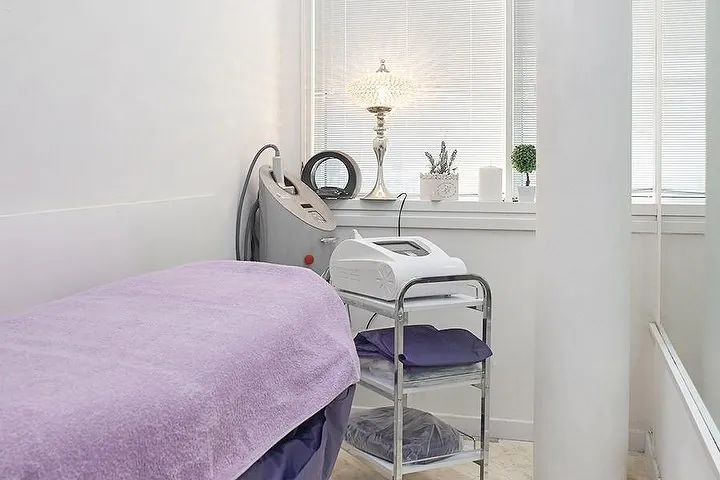 La cabina estetica luminosa con il lettino lilla e i macchinari