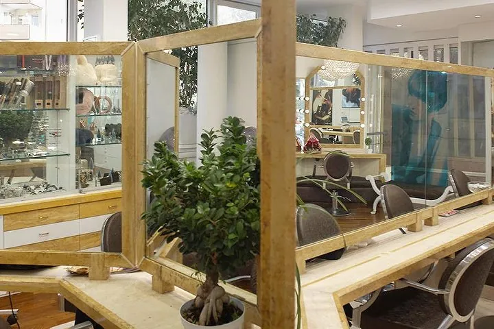 Gli specchi con cornice in legno e oro riflettono le postazioni e una pianta